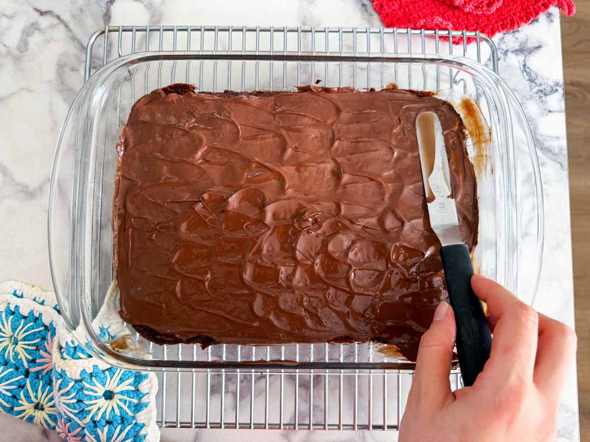 frosted brownies in pan on wire rack