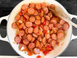 kielbasa and vegetables cooking in skillet