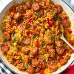 skillet kielbasa and rice being served with fresh herbs