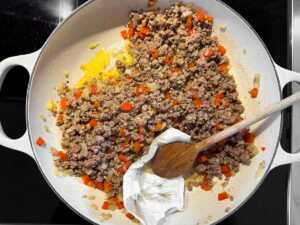 browned sausage and vegetables being drained
