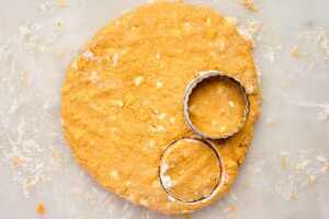 Cutting pumpkin biscuits from dough.