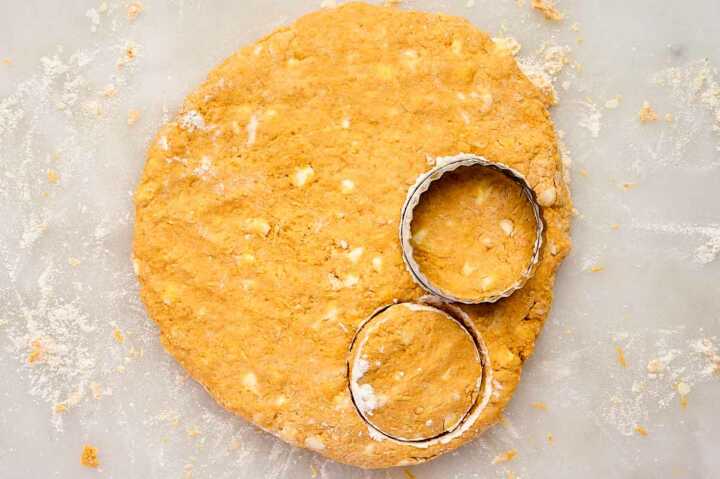 Cutting pumpkin biscuits from dough.