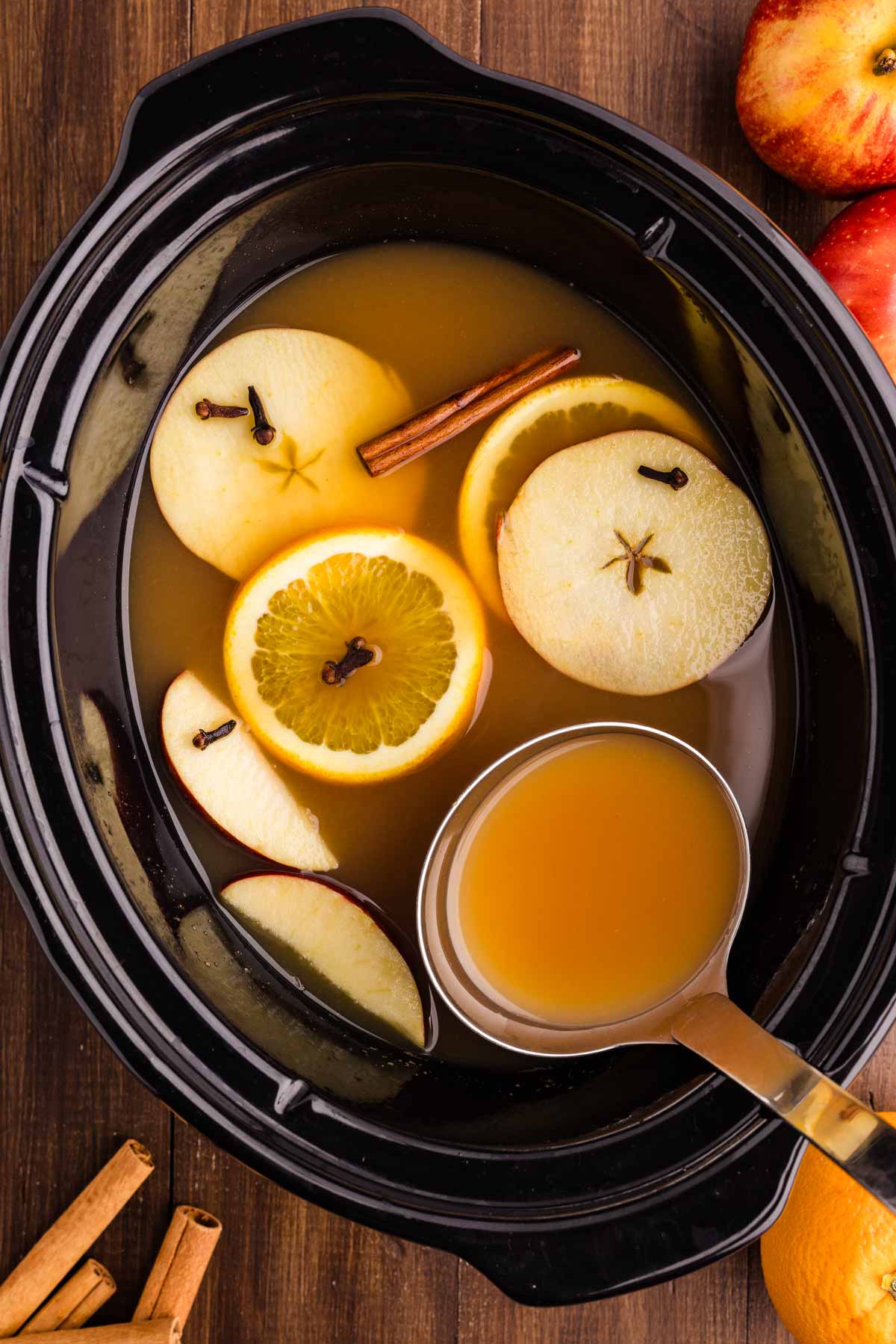 ladling more apple cider from the slow cooker