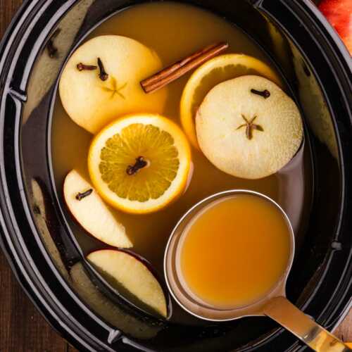 ladling more apple cider from the slow cooker