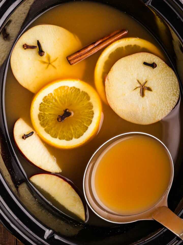 ladling more apple cider from the slow cooker