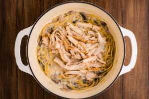 adding leftover turkey to tetrazzini in a pot