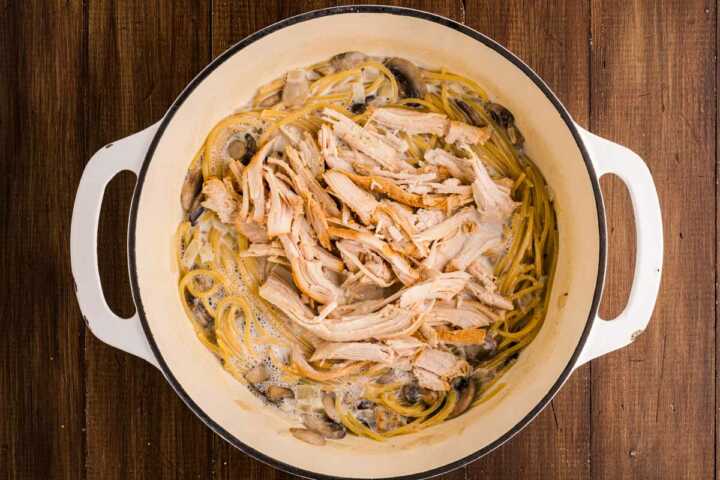 adding leftover turkey to tetrazzini in a pot