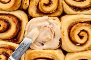 Spreading cinnamon rolls with frosting