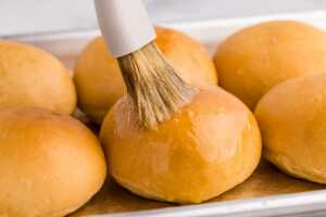 brushing baked shortcut buns with butter