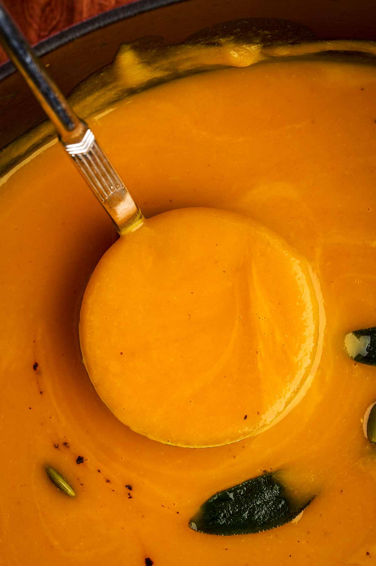 Ladle of creamy pumpkin soup.