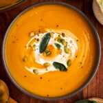 serving pumpkin soup in a cozy bowl