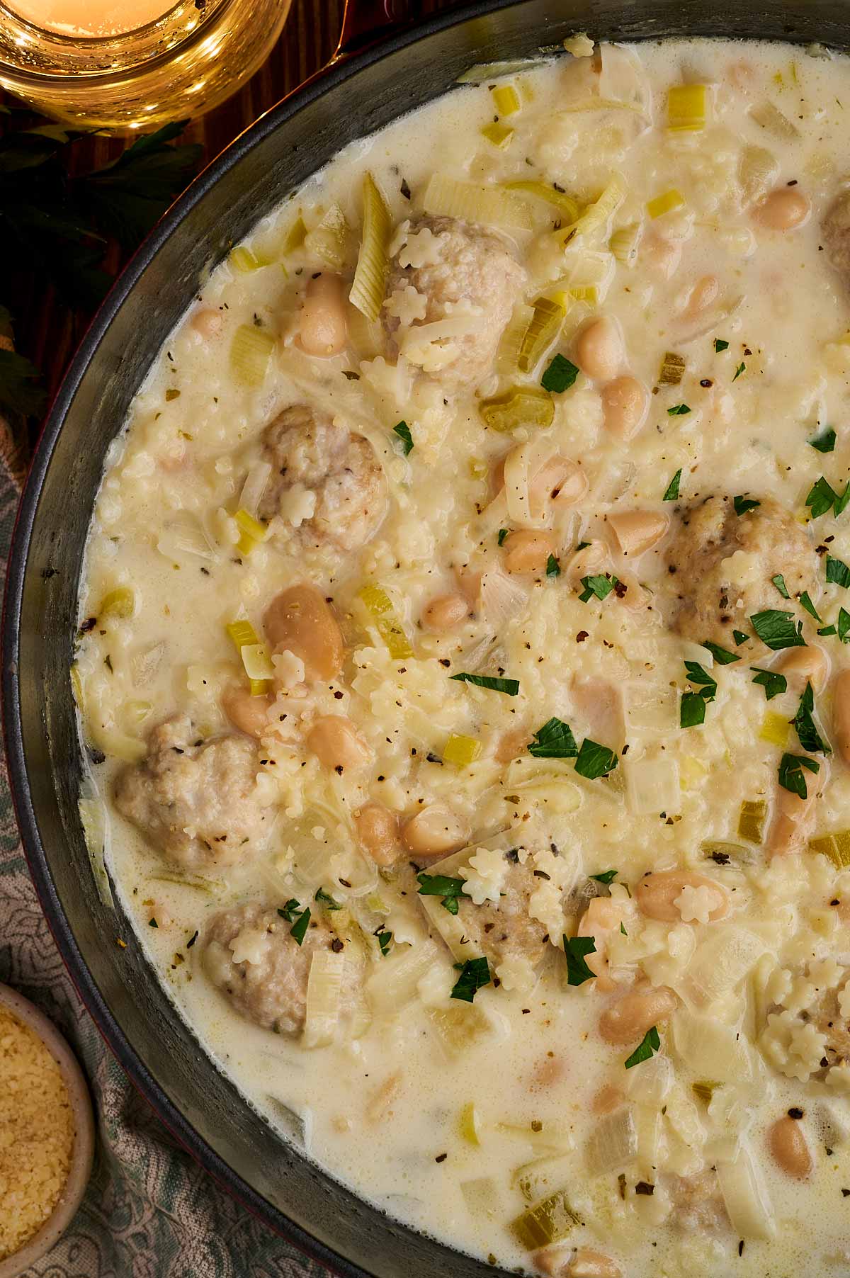 Creamy broth with beans and chicken meatballs in soup pot