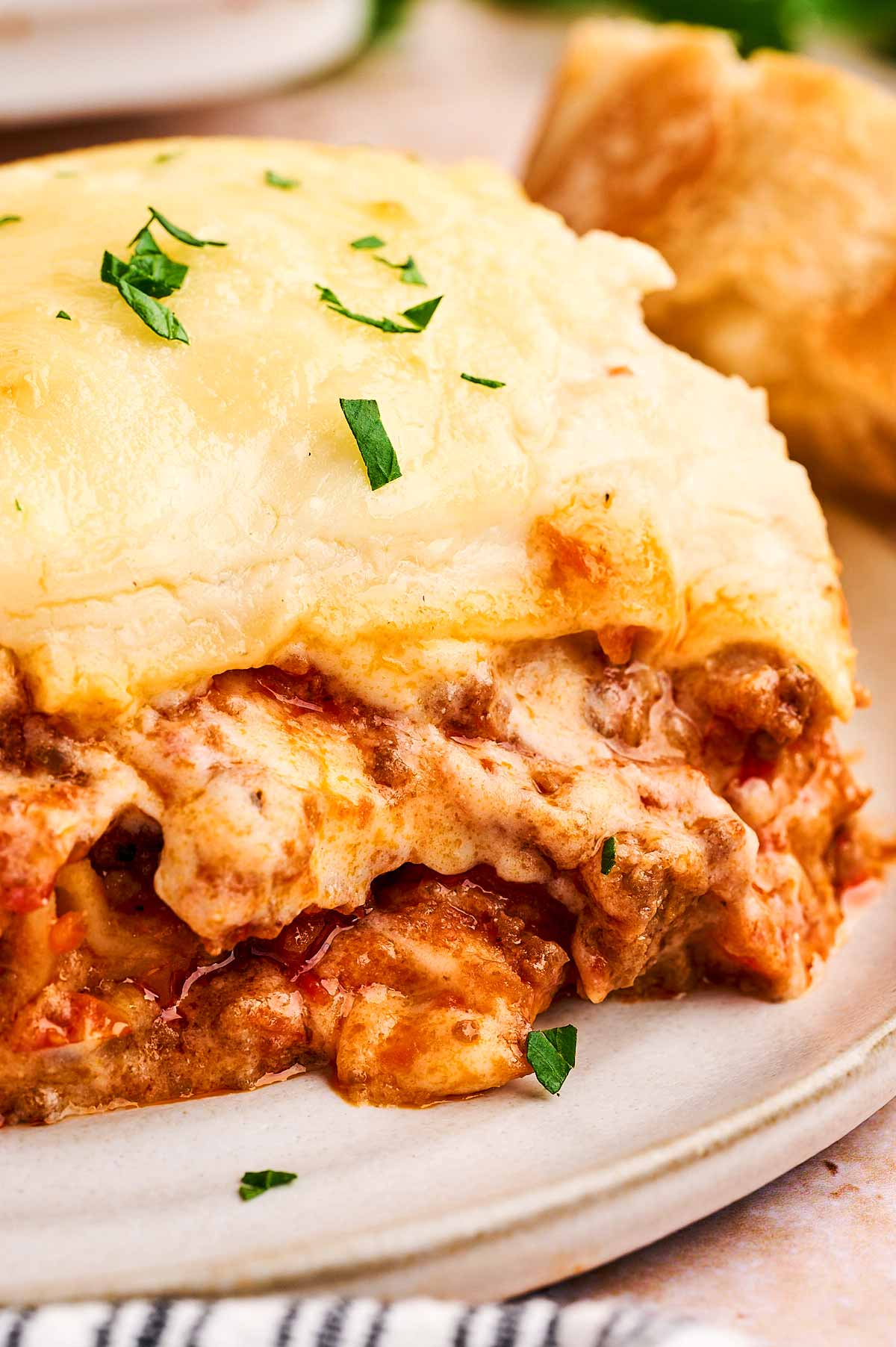 cheesy lasagna being eaten on a plate
