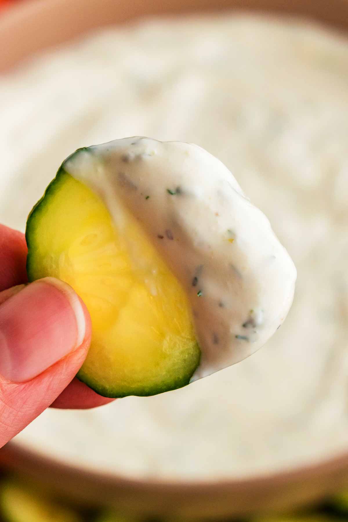 Dipping a cucumber slice into creamy dill dip.