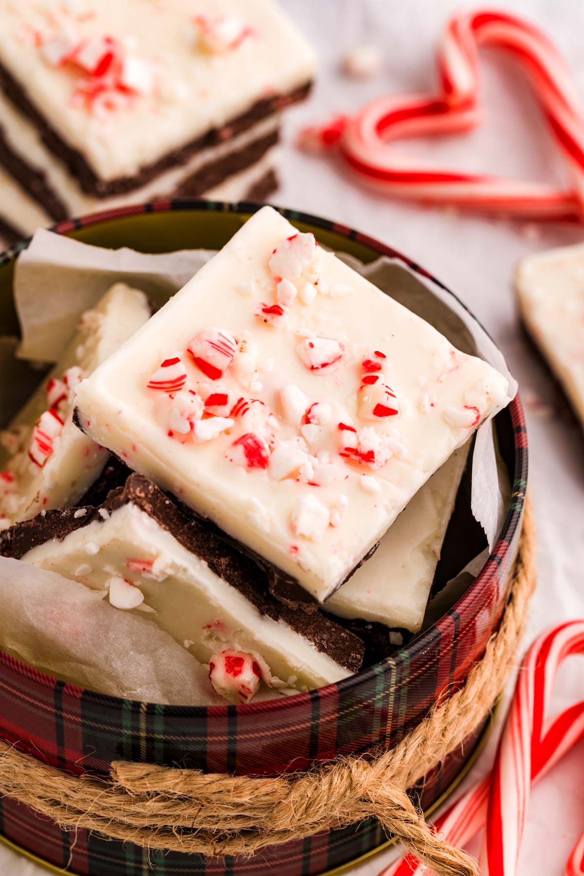 packing peppermint bark into a cookie tin