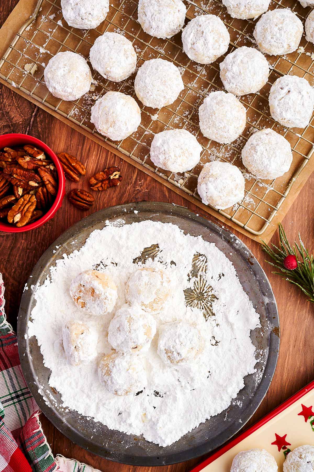 Dipping Snowball Cookies in powdered sugar.