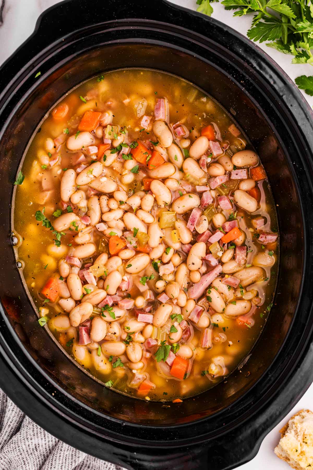 a slow cooker full of ham and bean soup