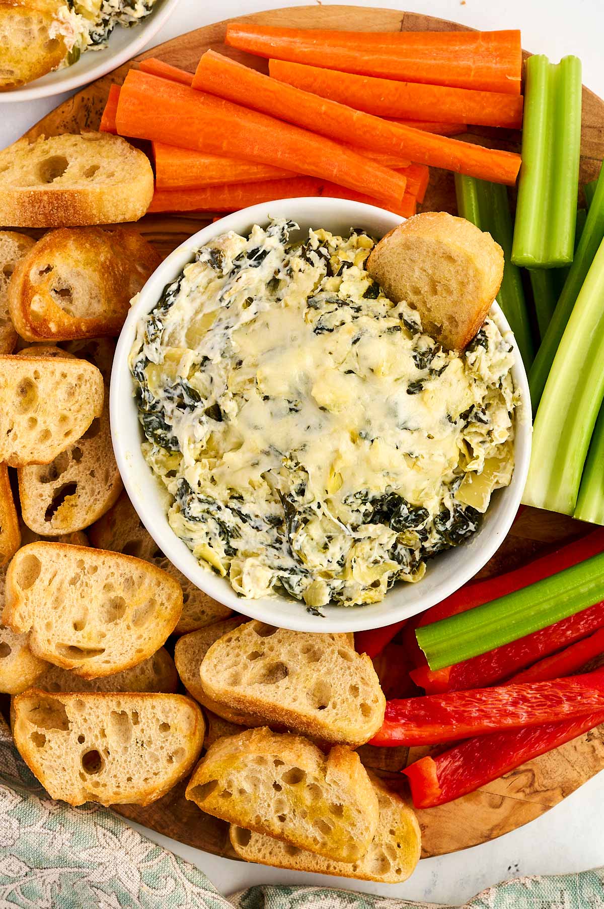 Spinach artichoke dip with vegetables and bread chips.