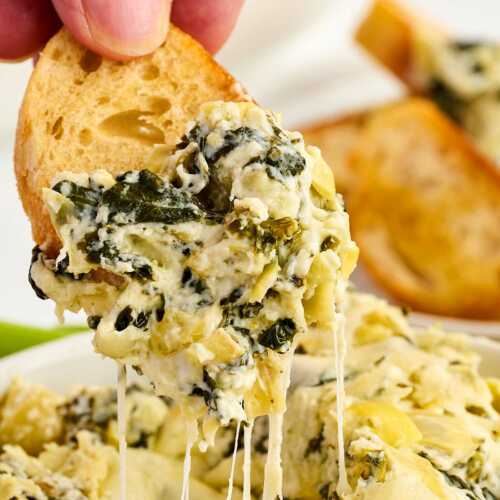Dipping a chip into spinach artichoke dip.