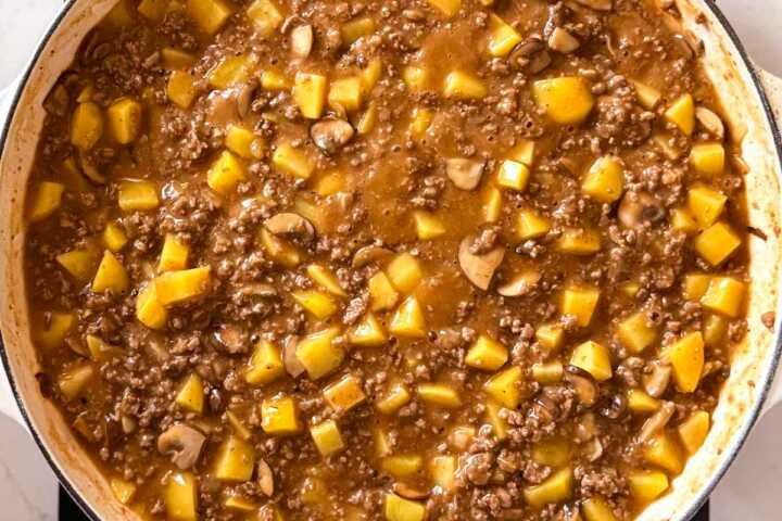 ground beef and potatoes simmering in skillet