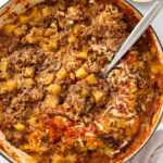 ground beef and potato casserole being served from oven-safe skillet