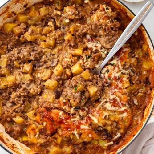 ground beef and potato casserole being served from oven-safe skillet