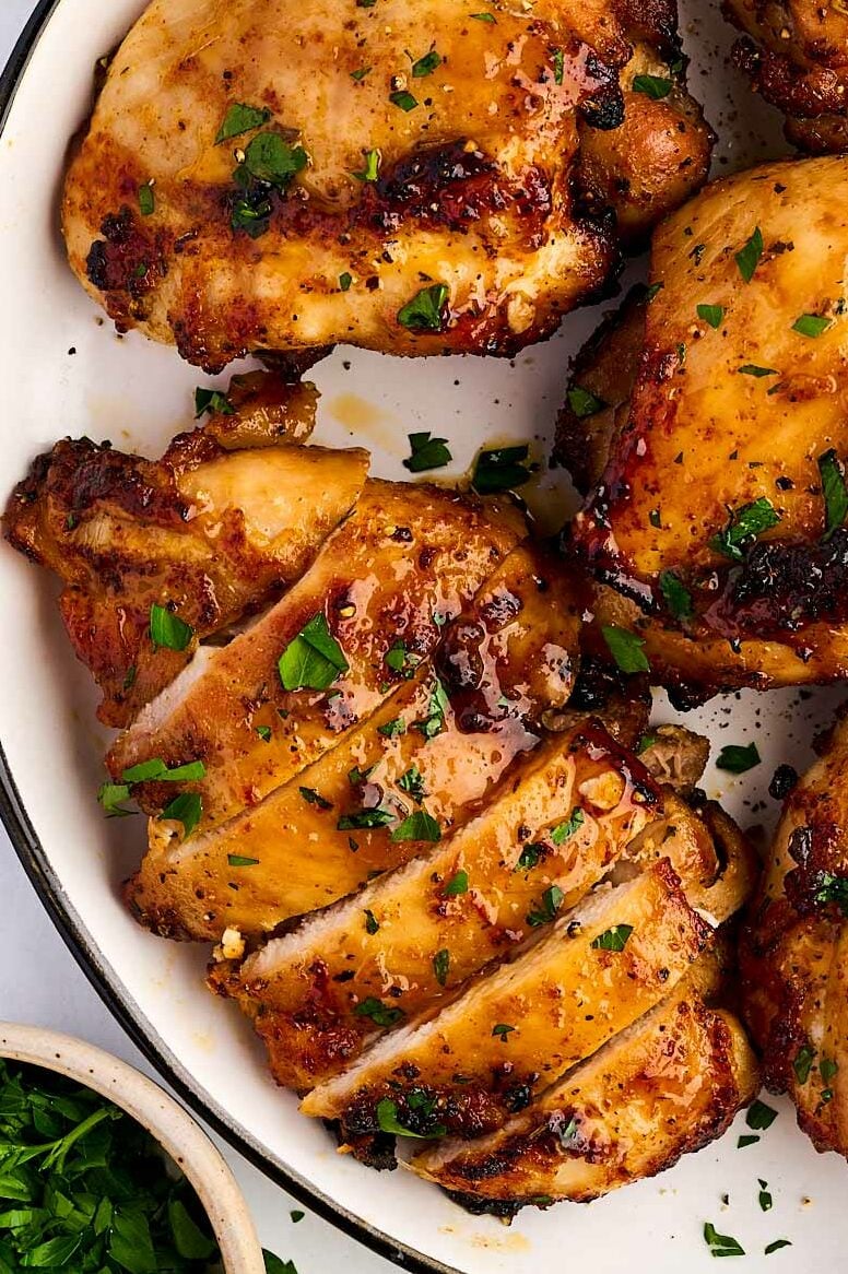 Sliced air fried chicken thighs on a plate.