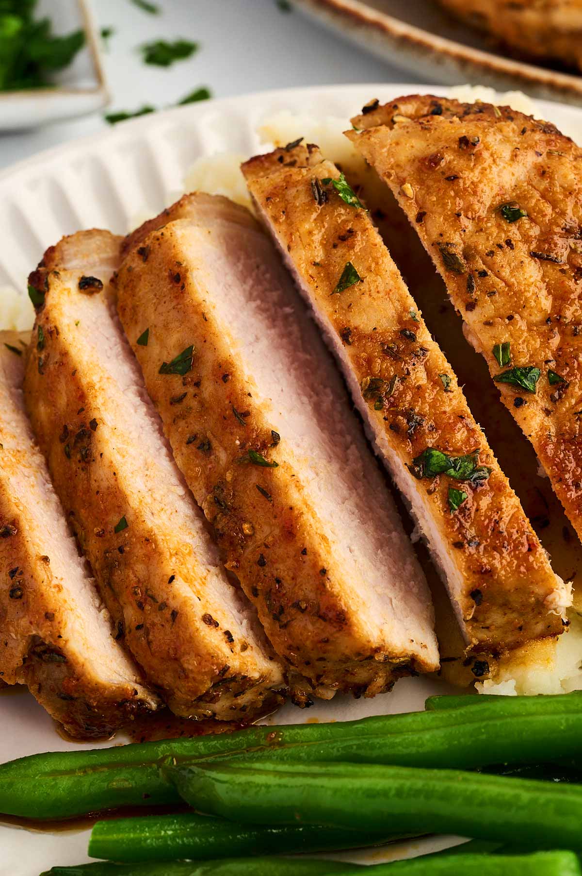 Sliced air fried pork chop on a plate.