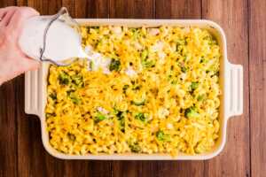 Adding half and half to a pasta casserole.
