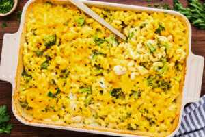 Serving a chicken broccoli pasta casserole from the dish with parsley.