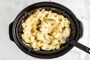 Mashing potatoes in a slow cooker.