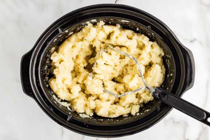 Mashing potatoes in a slow cooker.