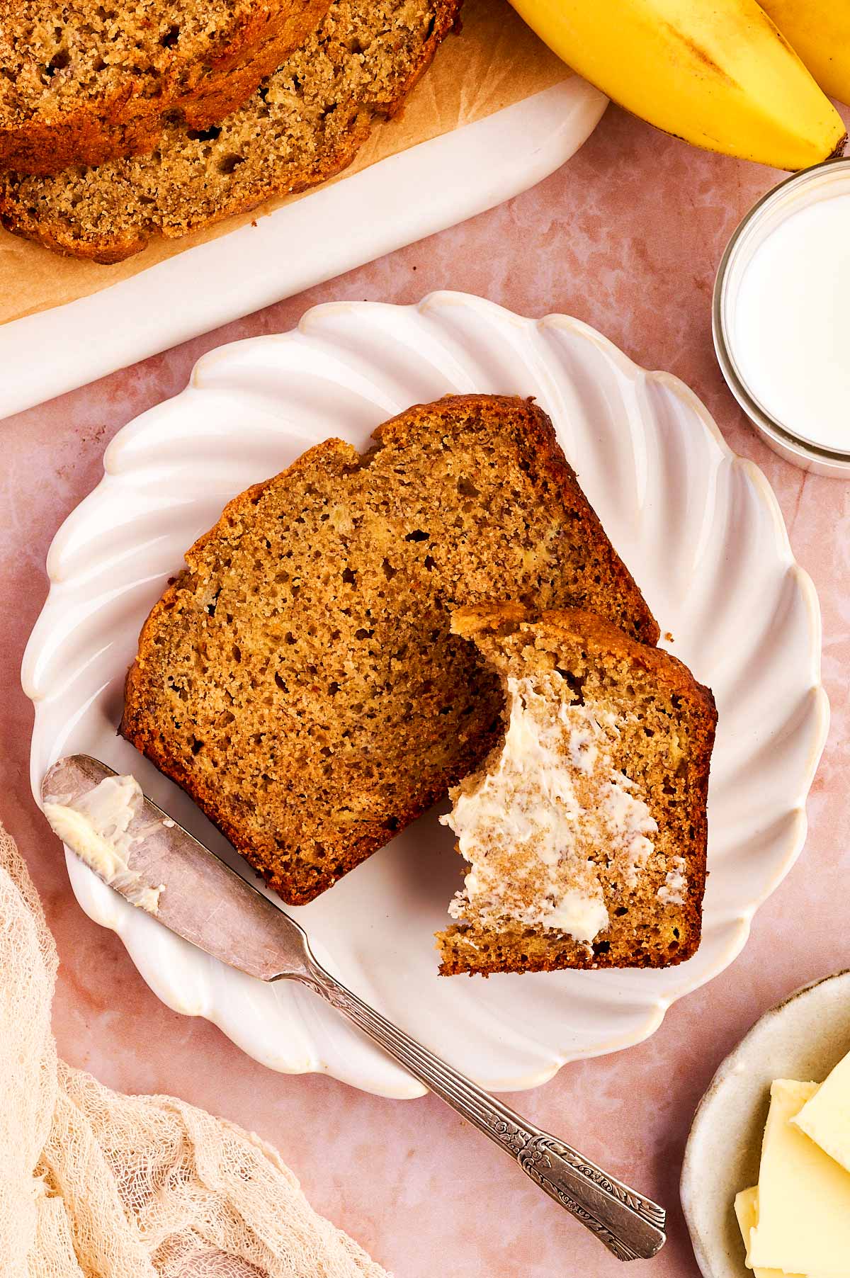 Slice of healthy banana bread on a plate with butter.