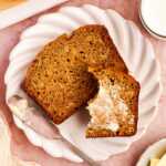 Slice of healthy banana bread on a plate with butter.