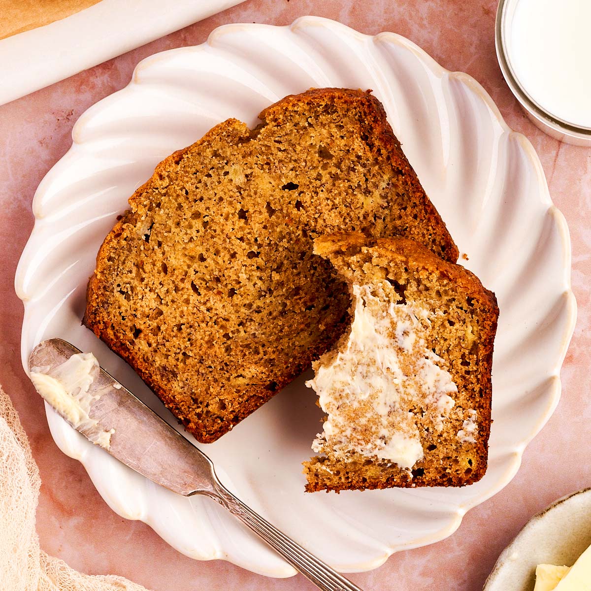 Slice of healthy banana bread on a plate with butter.