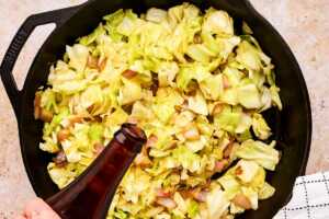 Using a bottle of beer to deglaze a skillet of sautéed cabbage.