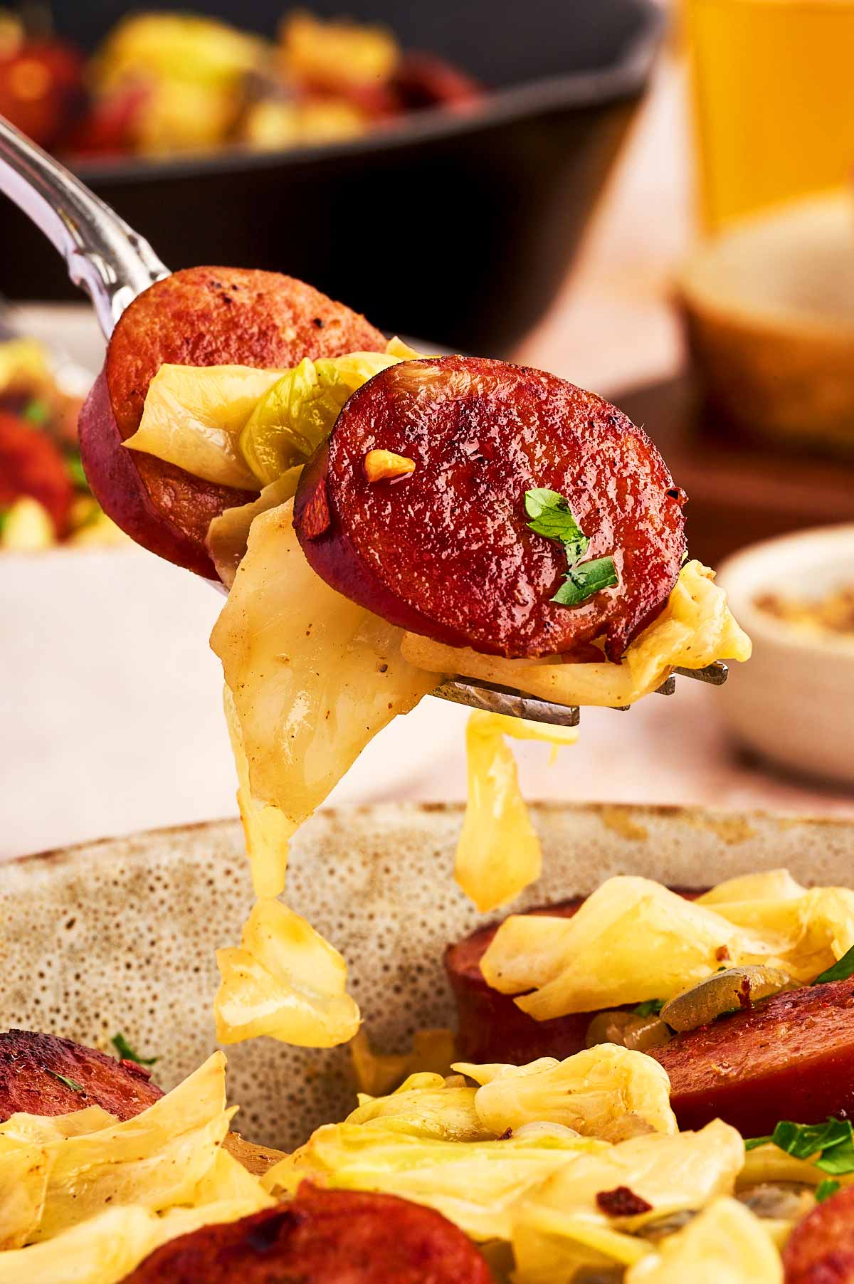 A forkful of kielbasa sausage and cabbage.