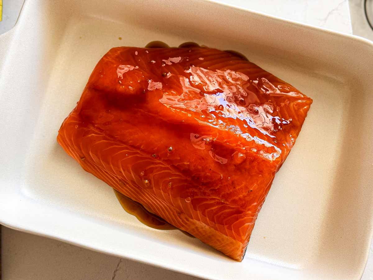 Raw salmon side covered in teriyaki sauce.
