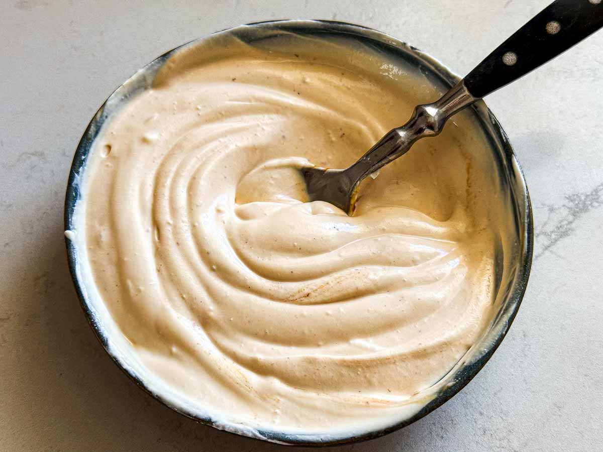 Spicy sour cream in a bowl with a spoon.