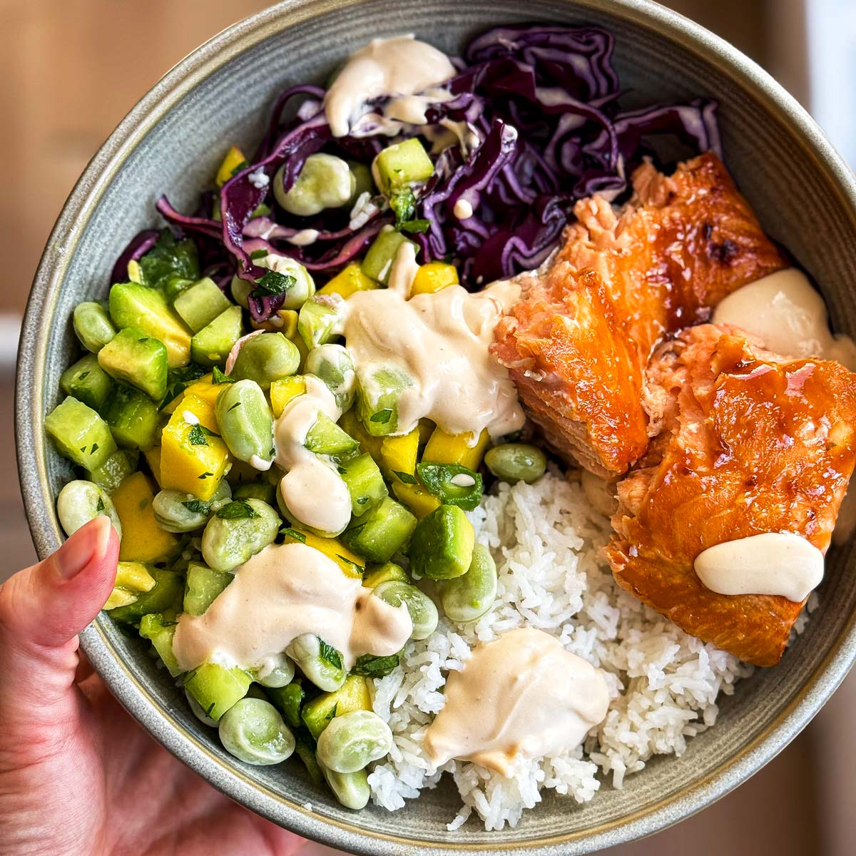 Holding a Teriyaki Salmon Bowl.