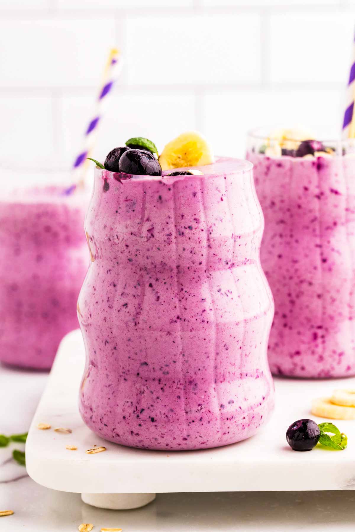 Glasses filled with blueberry banana smoothie.