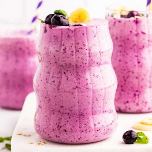 Glasses filled with blueberry banana smoothie.