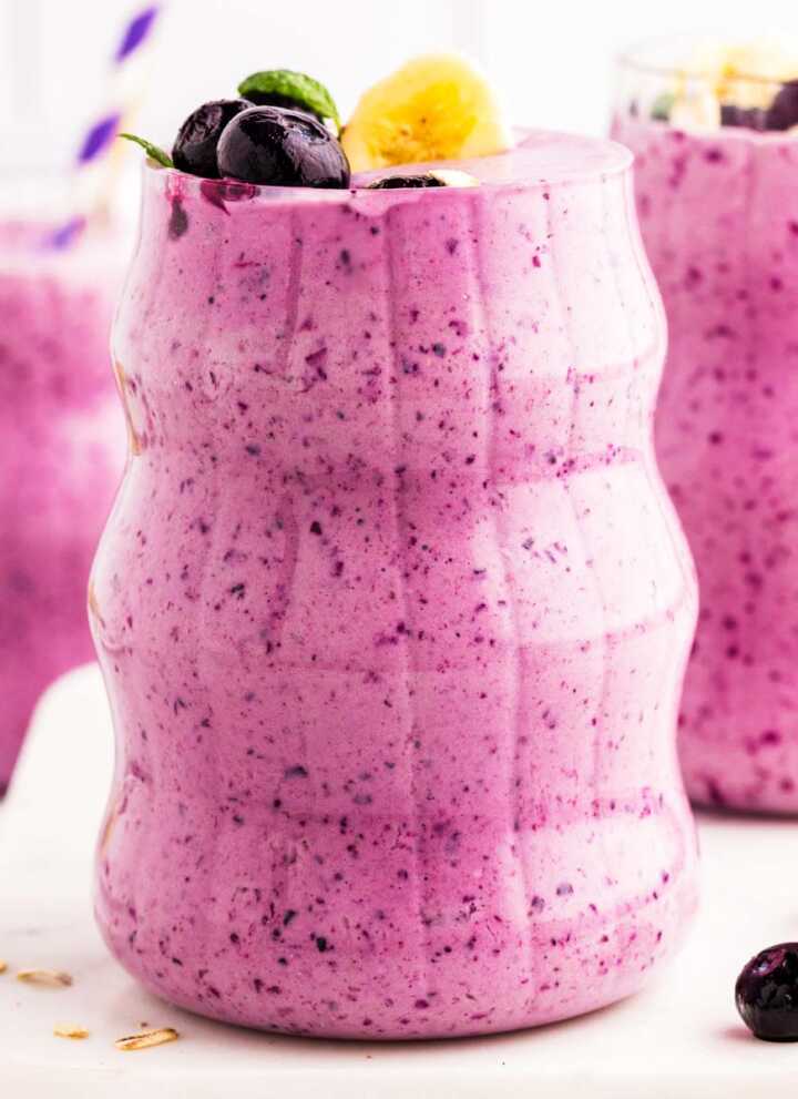 Glasses filled with blueberry banana smoothie.