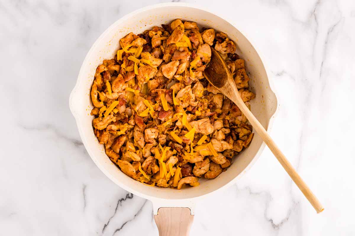 Cheddar bacon ranch chicken wrap filling in a skillet.