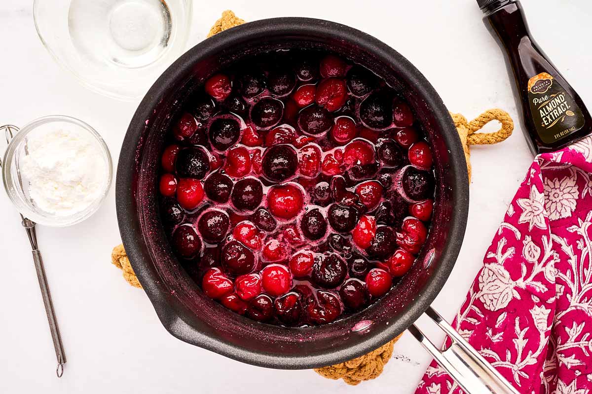 Simmering cherries for cherry filling.