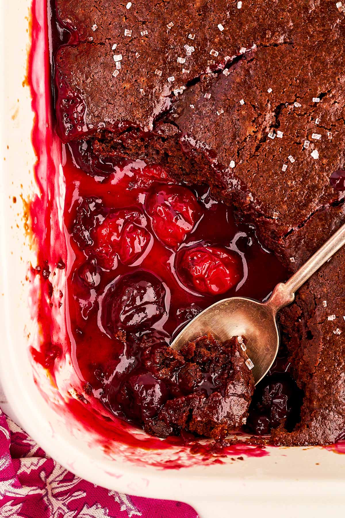 Chocolate cherry cobbler with a scoop taken out.