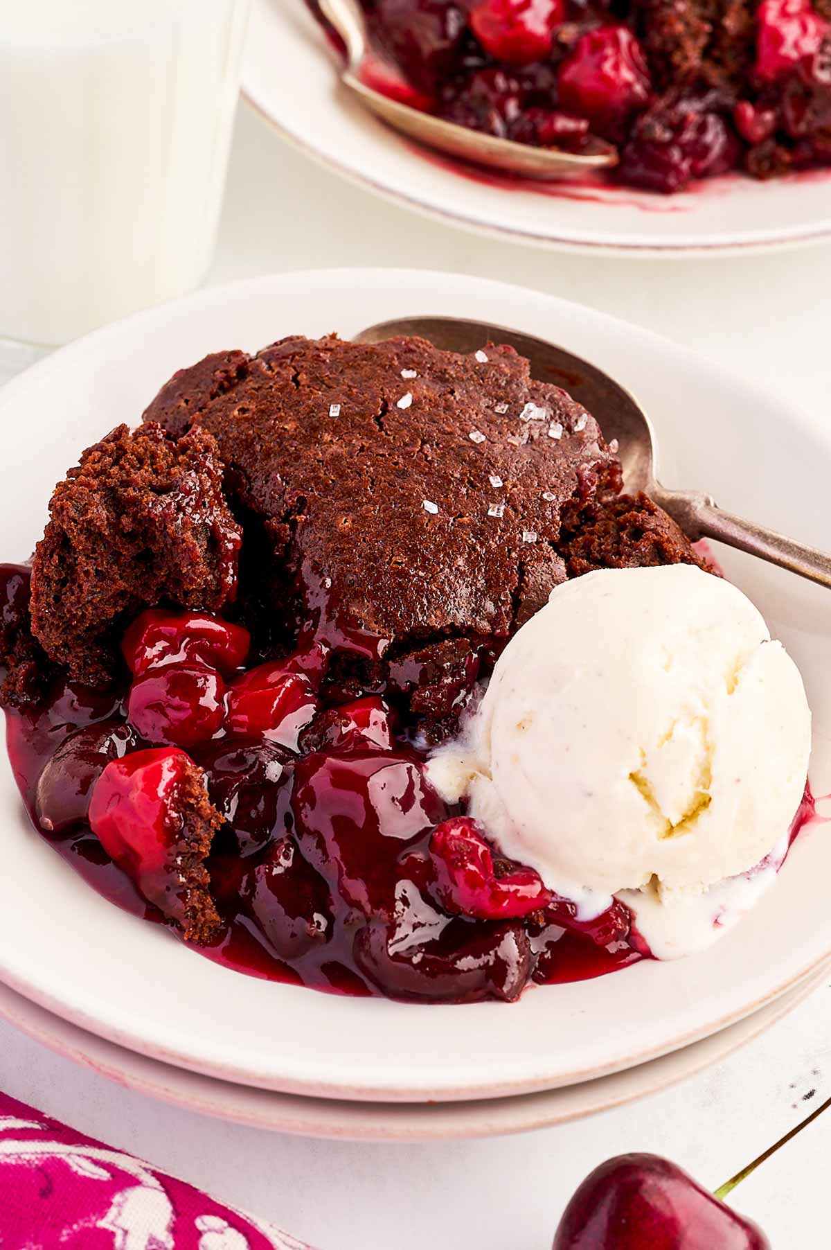 Bowl with chocolate cherry cobbler and a scoop of vanilla ice cream.