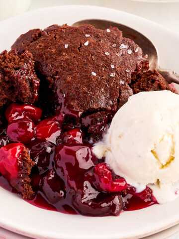 Bowl with chocolate cherry cobbler and a scoop of vanilla ice cream.