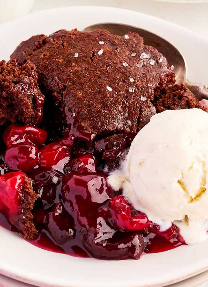 Bowl with chocolate cherry cobbler and a scoop of vanilla ice cream.