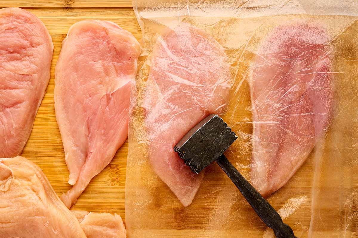 Pounding chicken breast flat.